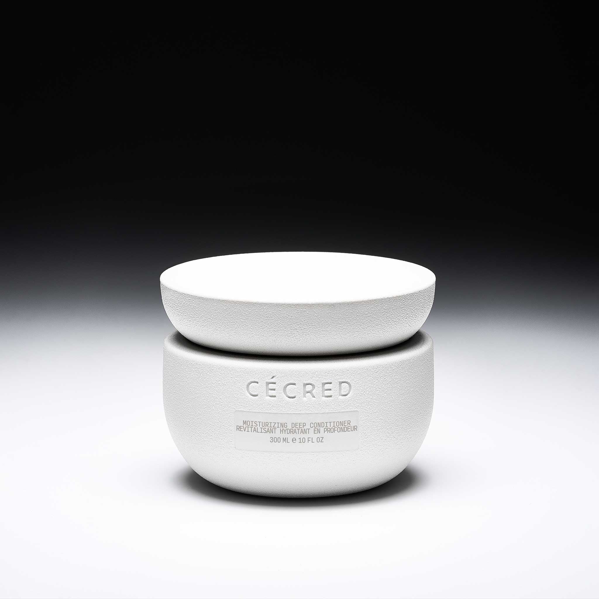 Cécred Moisturizing Deep Conditioner shown in sculpted jar on a black gradient background.