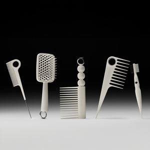 Set of hair styling tools including combs and a brush on a gradient background
