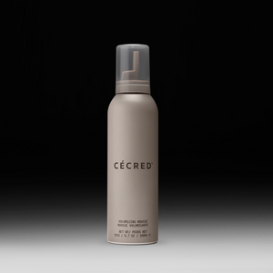 Cécred Volumizing Mousse bottle displayed upright on a gradient black-to-white background.