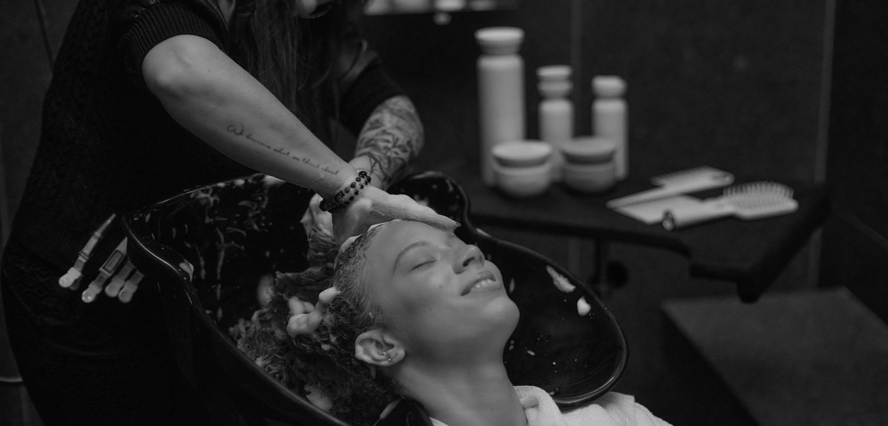Philanthropy Page hair dresser washing client's hair 