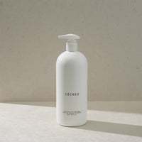 Cécred Moisturizing Deep Conditioner in the max size pump bottle, standing on a beige surface against a tan textured background