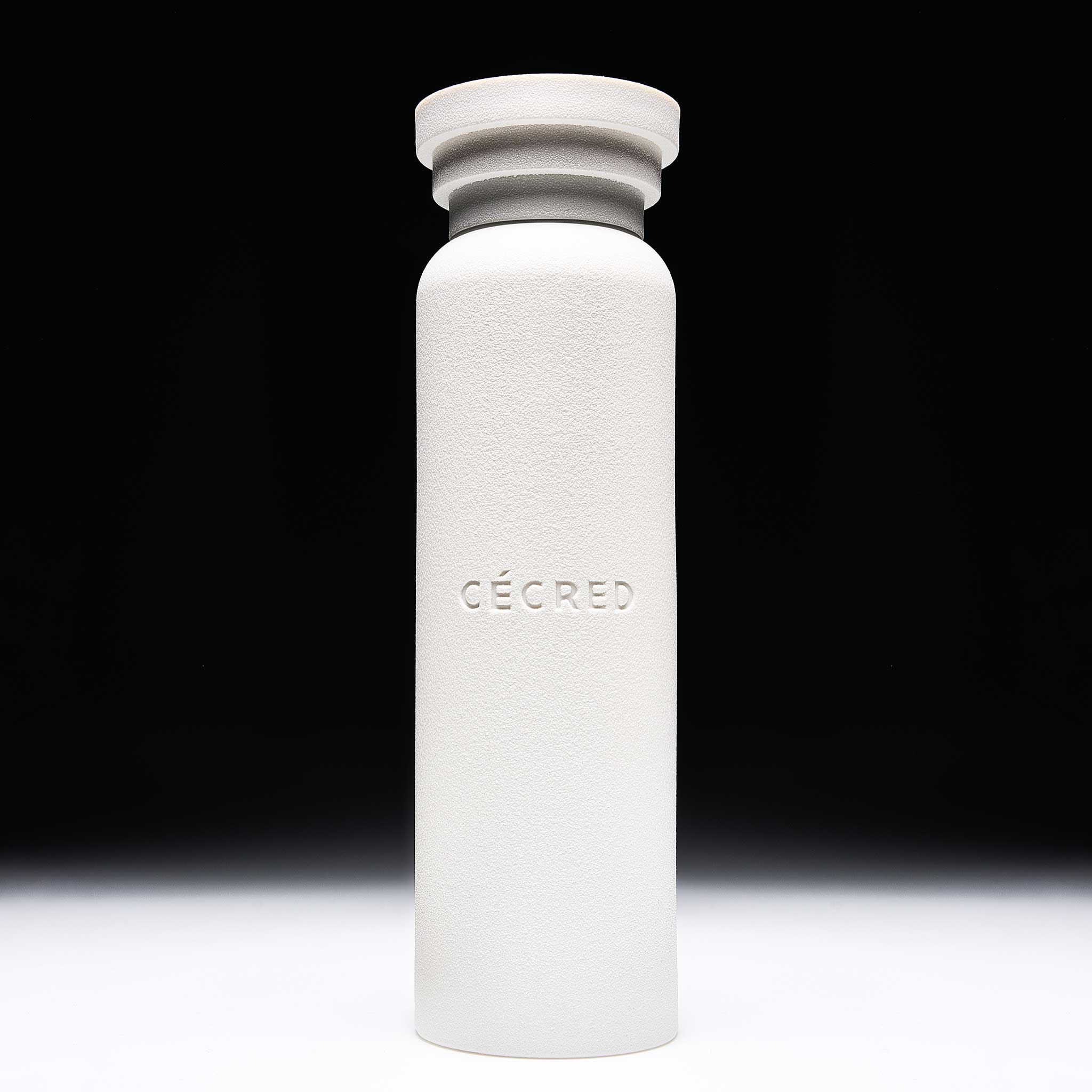  Cécred Ritual Shaking Vessel full bottle shown against a gradient grey background, highlighting its matte white textured finish and sculptural stacked cap